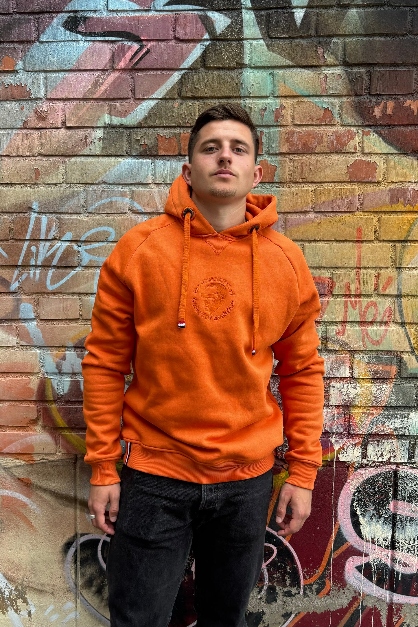 A regular sized orange hoodie, Regular fit, Super Soft, Badge on left sleeve