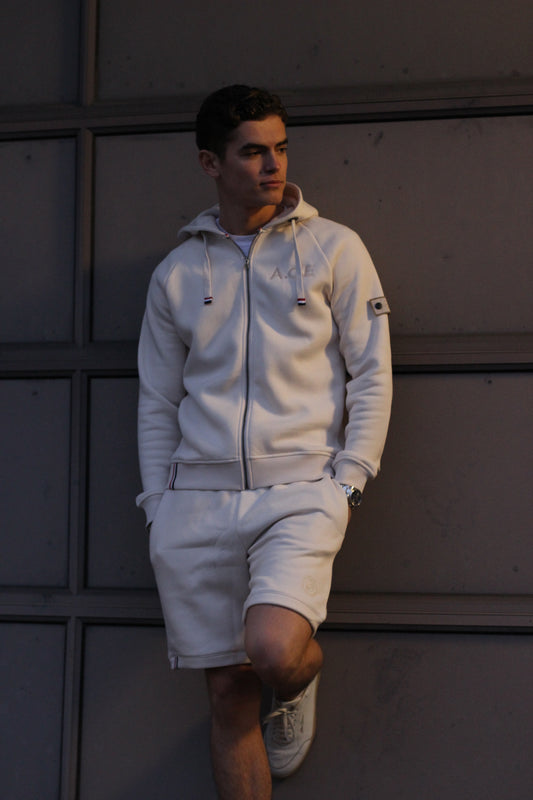 A regular fit white sand sweatshort, super soft, with an embroidered badge on the left leg.