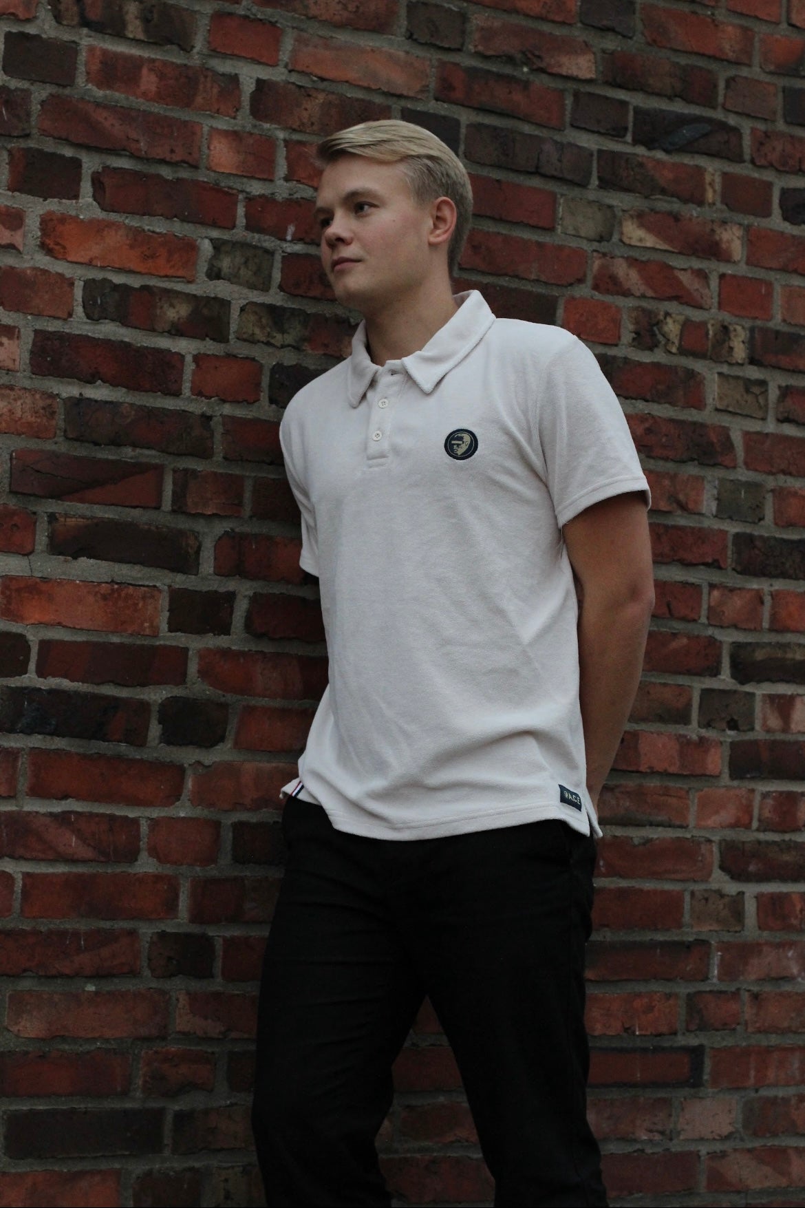 A regular-sized White Sand Terry Poloshirt, relaxed fit, super soft, with an ACE logo on the chest.